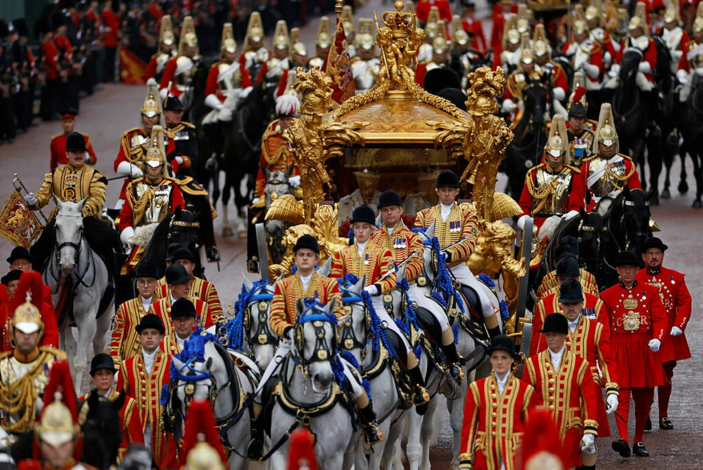 Image shows Armed Forces pesonnel escorting the royal carriage ahead of the King's coronation