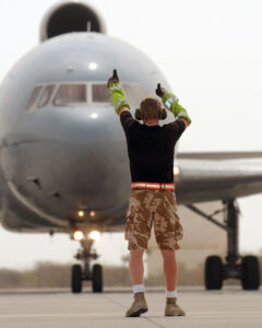 A member of RAF ground crew directs a Tristar aircraft on the runway [Photo by Sgt Pete Mobbs; Crown Copyright]