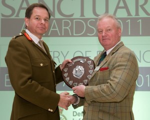 A member of the Cape Wrath Training Centre team collects the 'Heritage Project' award from Major General Nick Ashmore, at the 2011 Sanctuary Awards. (Crown Copyright)