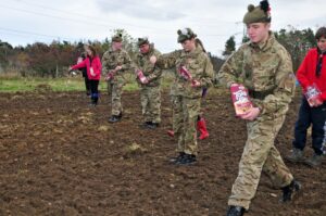 Army cadets and Scouts scattering seeds for wild flowers