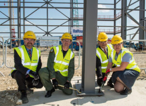 Station Commander Gp Capt Simon Edwards & Head of Establishment Gp Capt Polly Perkins put the finishing touches to first part of A400M hangar’s steelwork, with Andy Duff of Balfour Beatty (l) & Airbus Military Chief Executive Richard Thompson. [Crown Copyright/MOD2015]