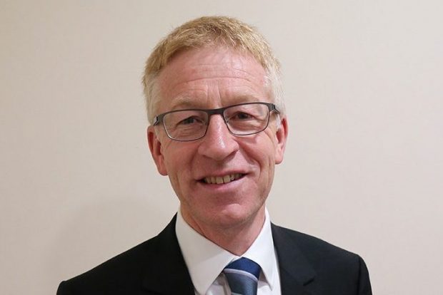 Head and shoulders image of Graham Dalton, a white man with fair hair and glasses, wearing a suit and tie. He is smiling.