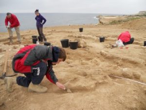 The team excavating an Amphora in a Roman building at Dreamer's Bay. Note the wet weather clothing….it isn’t always hot in Cyprus! [Crown Copyright, MOD 2017]