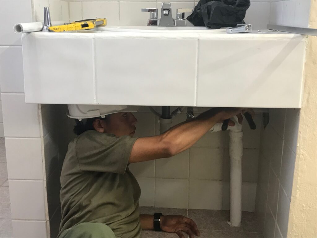 A LEC from Belize working on some plumbing. [Crown Copyright]