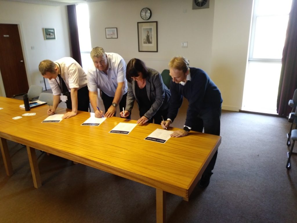 Robert (Bob) Phillips, Contract & Infrastructure Manager, DIO, David Demock, High Voltage Engineering Manager, C&P Engineering Services Ltd, Claire Travis, Project Manager, Landmarc Support Services and Fraser Faulks, Associate, DSSR are the first to sign the new Project Charter on the High Voltage Power Replacement Project at Kirkcudbright Training Area in Scotland.