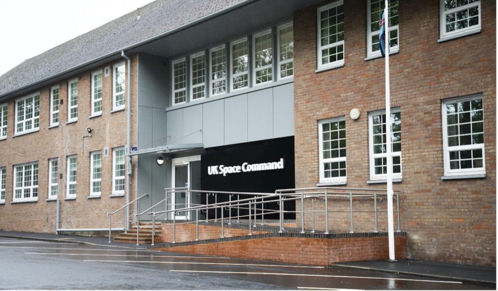 An external picture of the new UK Space Command HQ. It's a two story brick building with the words 'UK Space Command' written in white on a black background above the entrance.