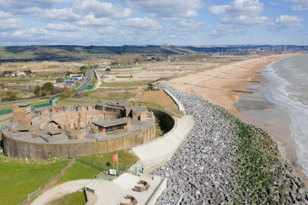 A view of the coastal defences showing a rock revetment and groynes along a stretch of beach