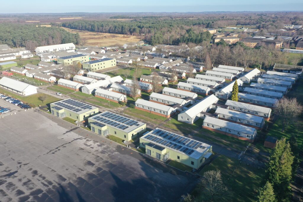 An aerial view of the three existing, single storey NetCAP accommodation units at Brunswick Camp. To their rear, behind a block of older barracks buildings, can be seen the two new double storey facilities.