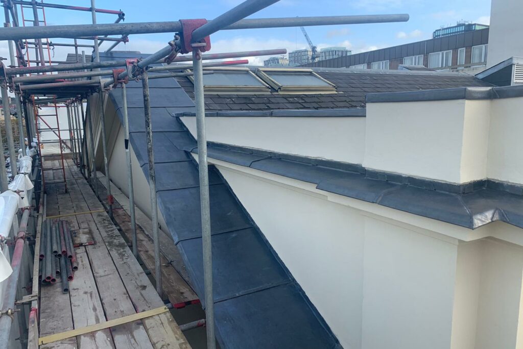 A section of roofing surrounded by scaffolds and wooden boards