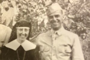 A black and white picture of a man in US military uniform and a Sister wearing a habit and black dress.