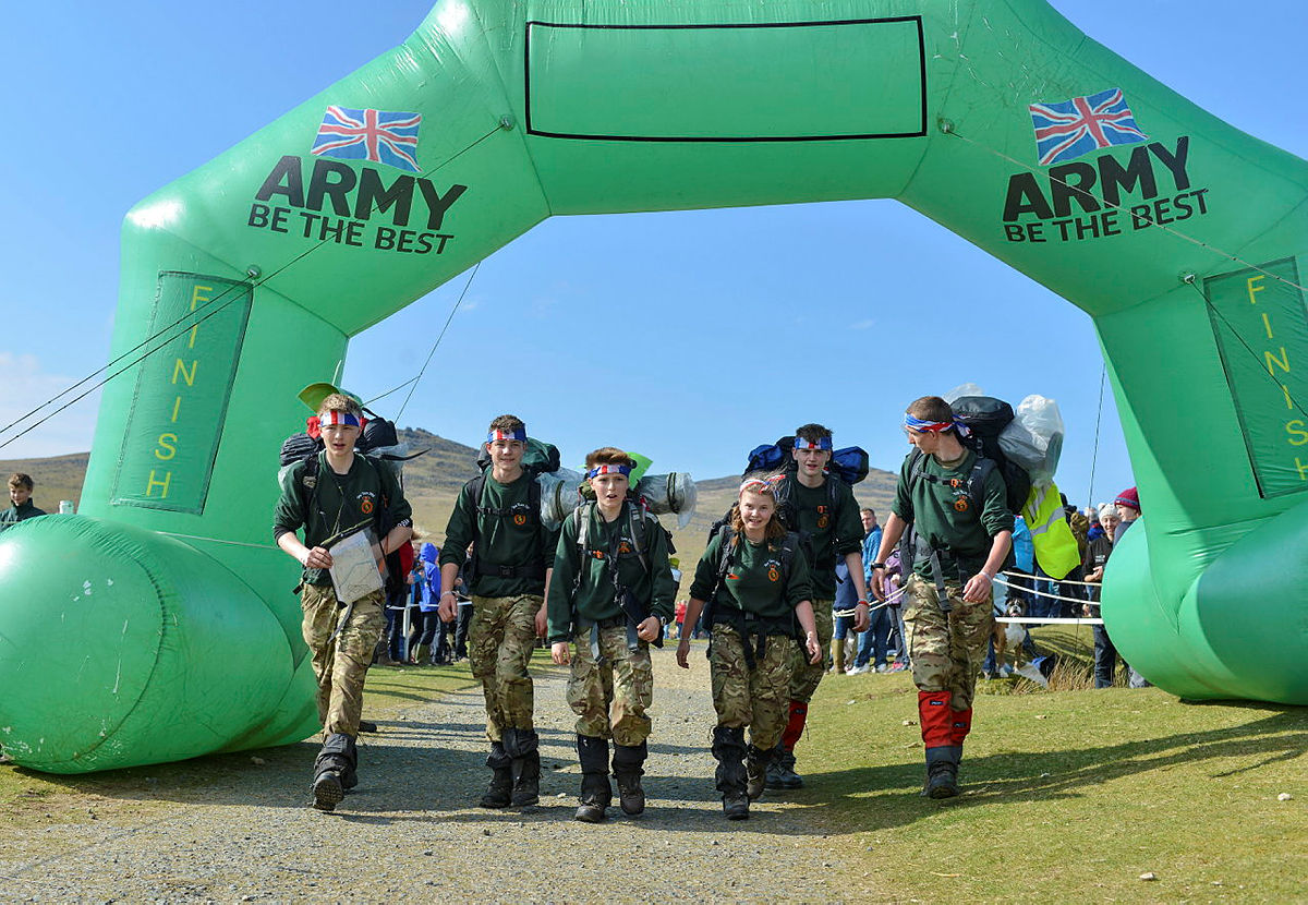 A group of Army Cadets walk under the finish banner as they reach the end of their Ten Tors expedition.